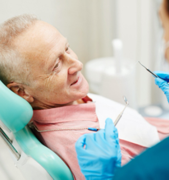 An older man having his teeth checked by the dentist