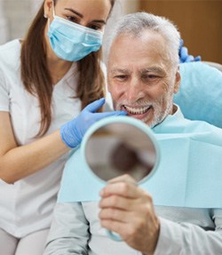 a patient looking at his teeth in a mirror