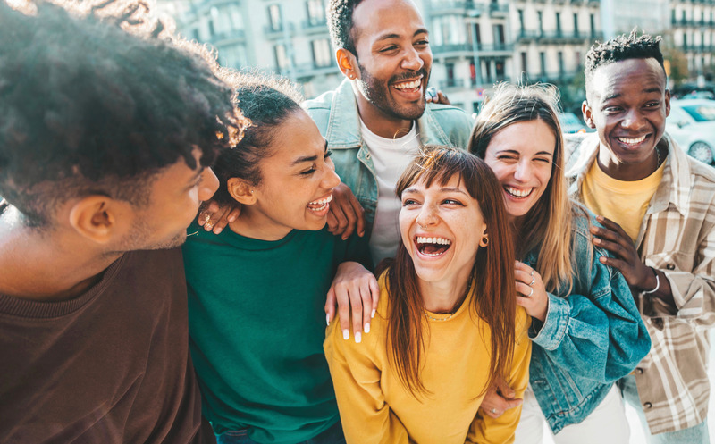 Patient smiling with friends after getting dental implants